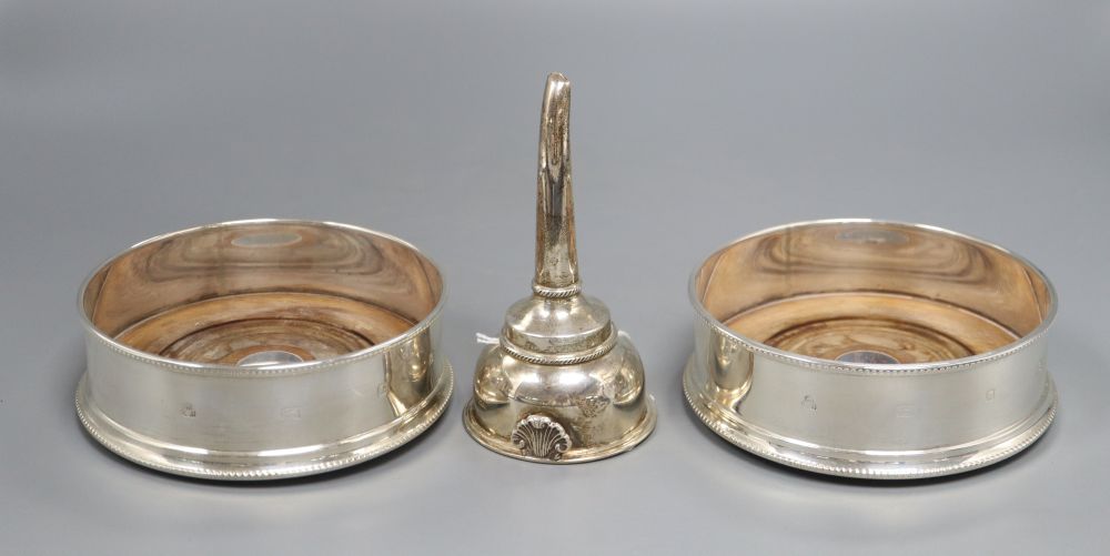 A pair of bottle coasters with beaded rims and turned hardwood bases, London 1991, width 14cm and a George III style wine funnel